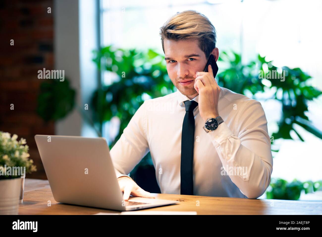 Businessman working in office. Handsome employee talking on the phone. Stock Photo