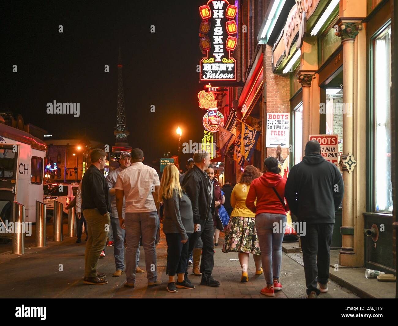 People enjoy Broadway by night in Nashville. This historic street in Music Row is famous for its nightlife and country music bars. Stock Photo