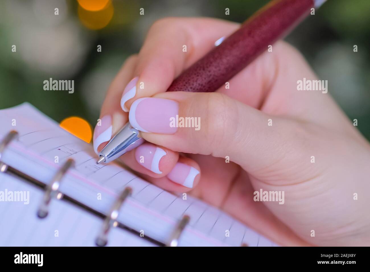 Woman hand holding pen and writing to do list in vintage notebook ...