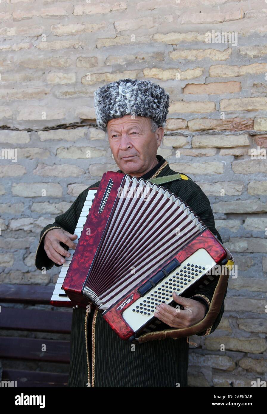 Street performer in Khiva playing the accordion Stock Photo