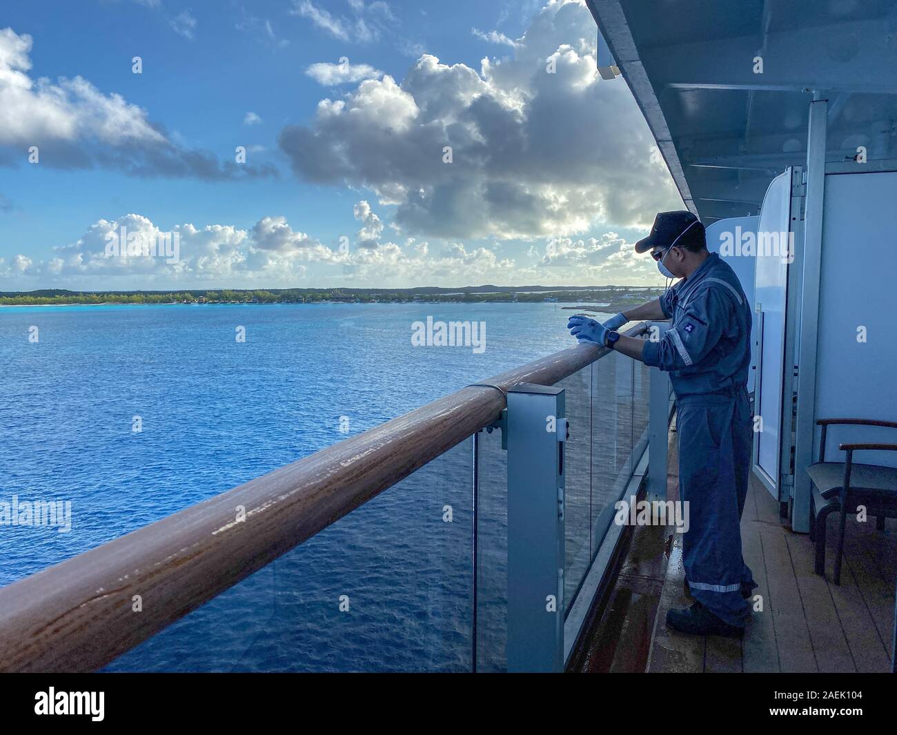 Half Moon Cay/Bahamas-10/31/19: The Holland America Line Zuiderdam cruise ship maintenance crewman sanding and painting the railing. Stock Photo