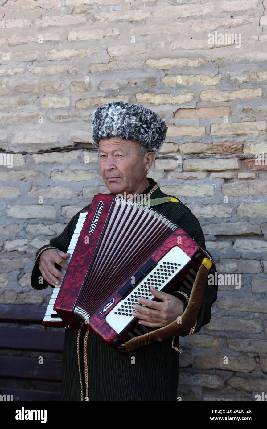 Street performer in Khiva playing the accordion Stock Photo