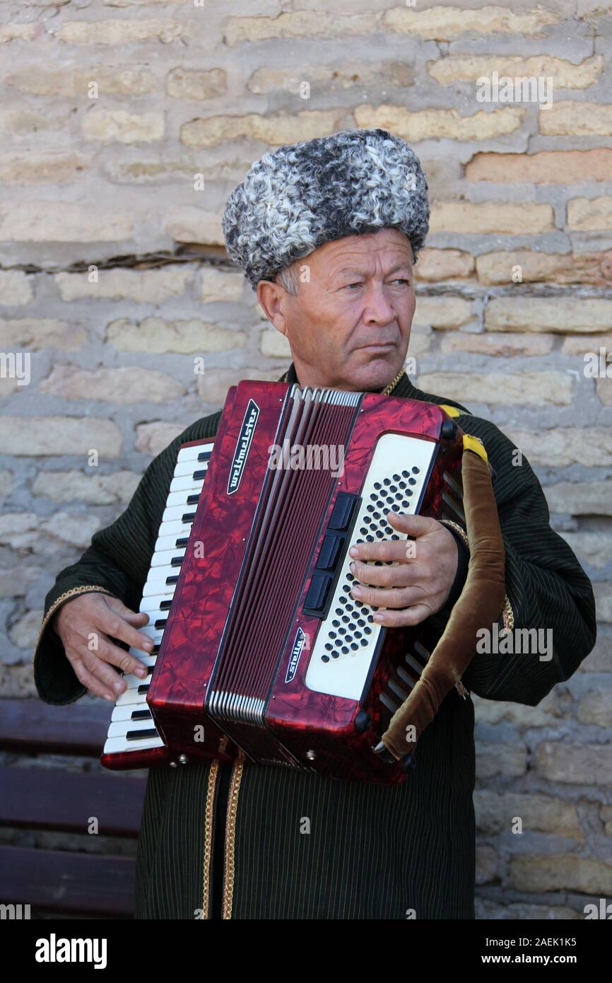 Street performer in Khiva playing the accordion Stock Photo