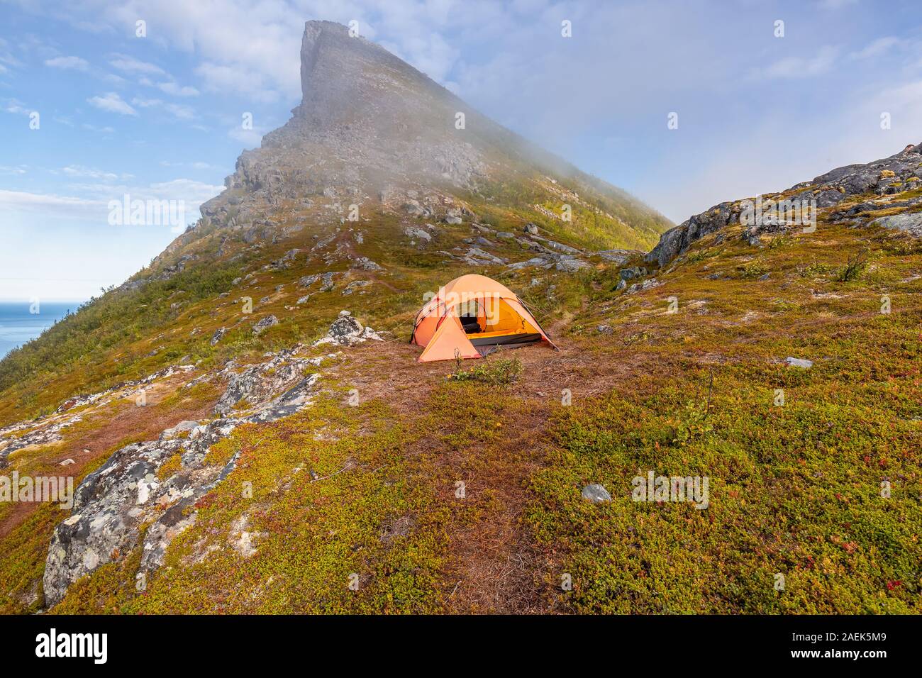 Tent on mountain ridge over clouds adventure journey traveling outdoor in  Norway active vacations sunset Segla mountain, Senja Stock Photo - Alamy