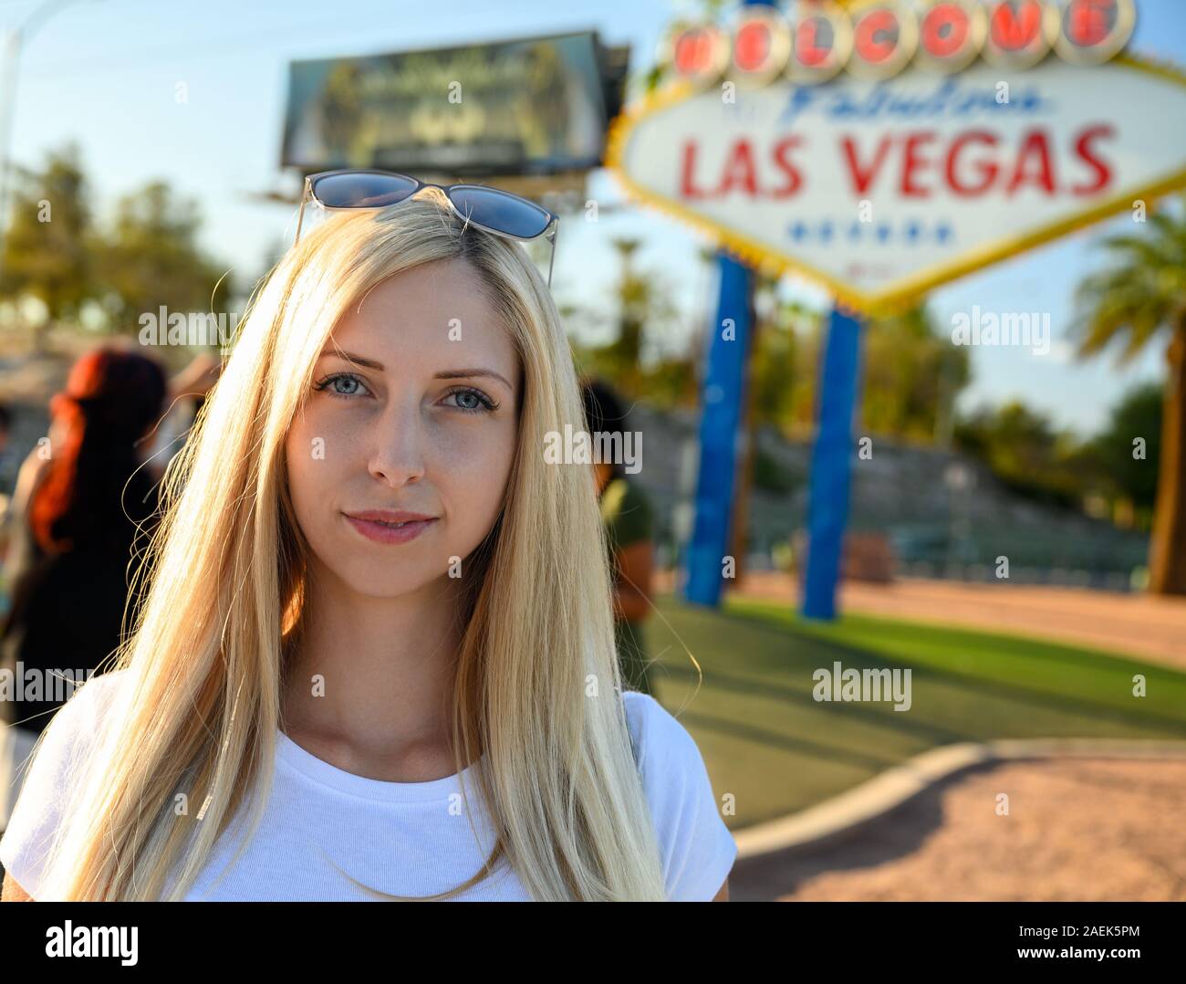 Portrait of a gorgeous blonde woman on the Las Vegas Strip standing under the world famous Welcome To Fabulous Las Vegas Nevada sign, USA Stock Photo
