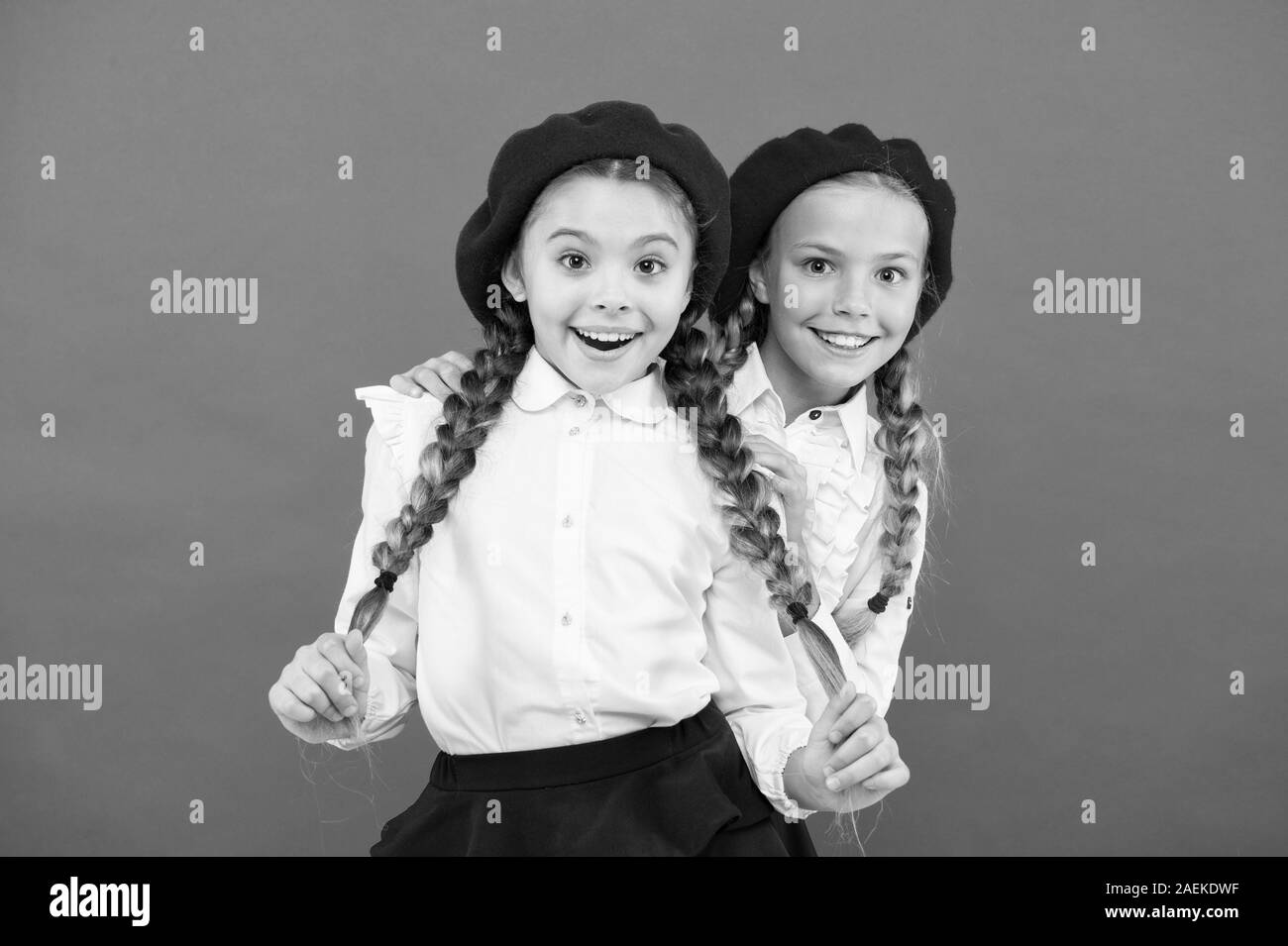 Friendship means support. Girls best friends on red background. Cute playful sisters schoolgirls