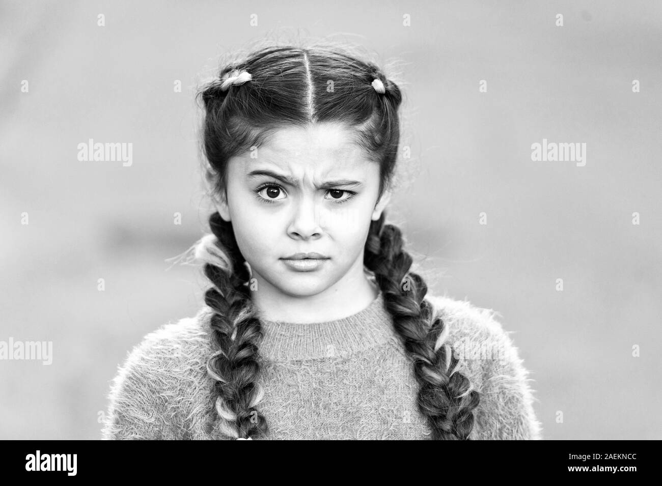 Suspicious look. Kanekalon strand in braids of child. Braided hairstyle  concept. Girl with braided hair style pink kanekalon. Hairdresser salon.  Braided cutie. Little girl with cute braids close up Stock Photo -