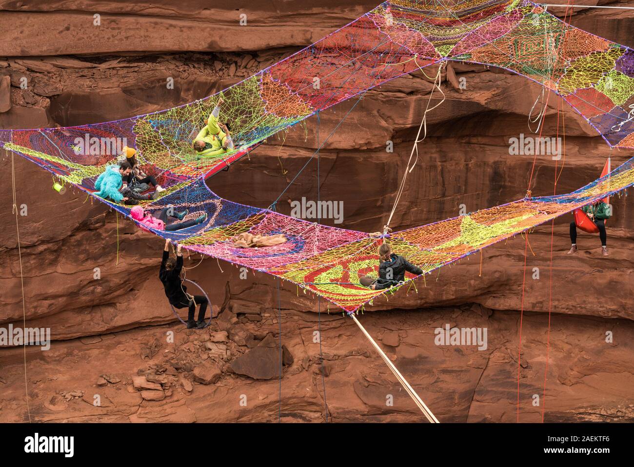 A group of slackliners play on the Space Net hundreds of feet above Mineral Canyon near Moab, Utah during a highline gathering. Stock Photo