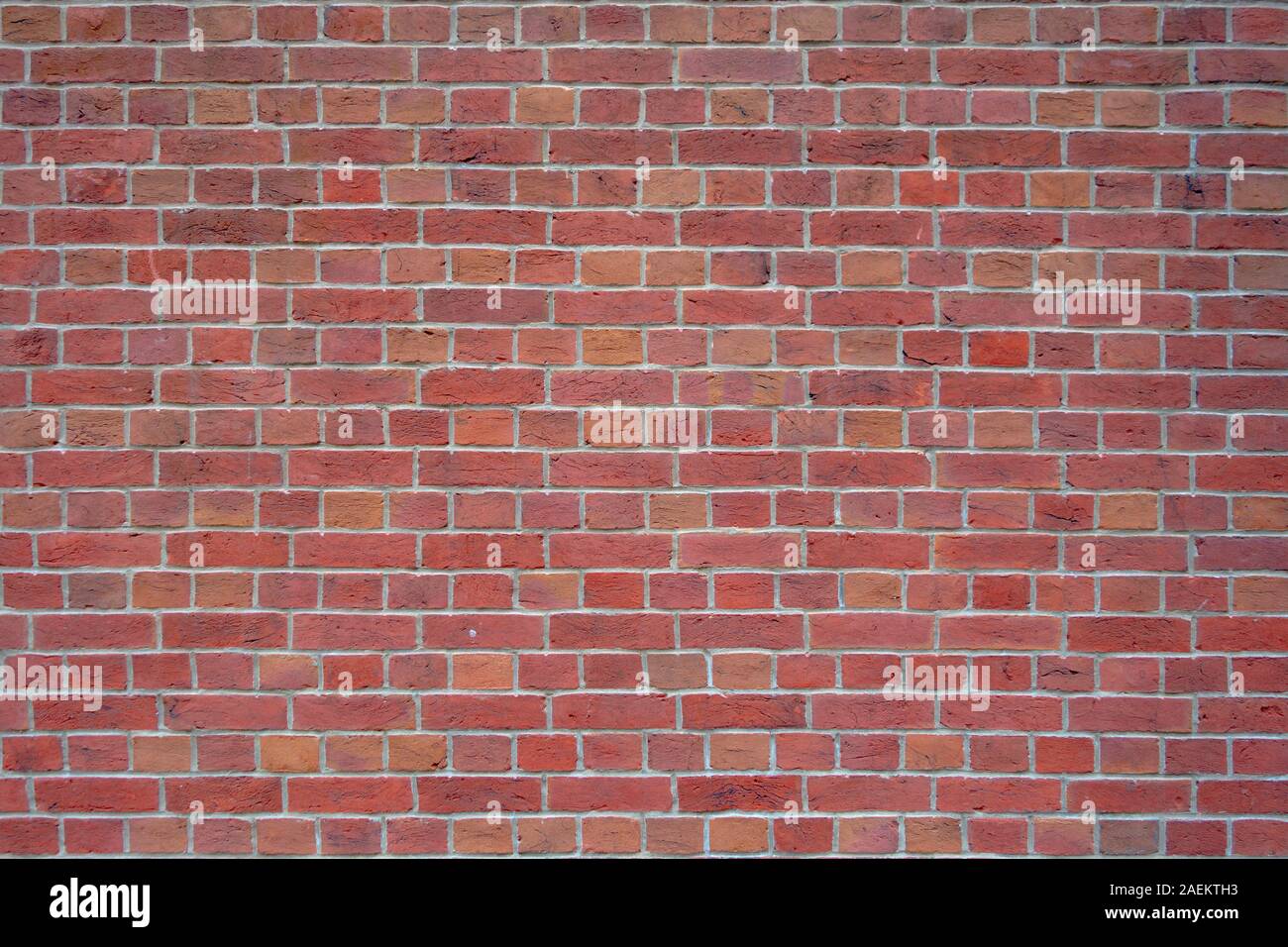 exposed red brick wall with grey cemented joints background backdrop surface Stock Photo