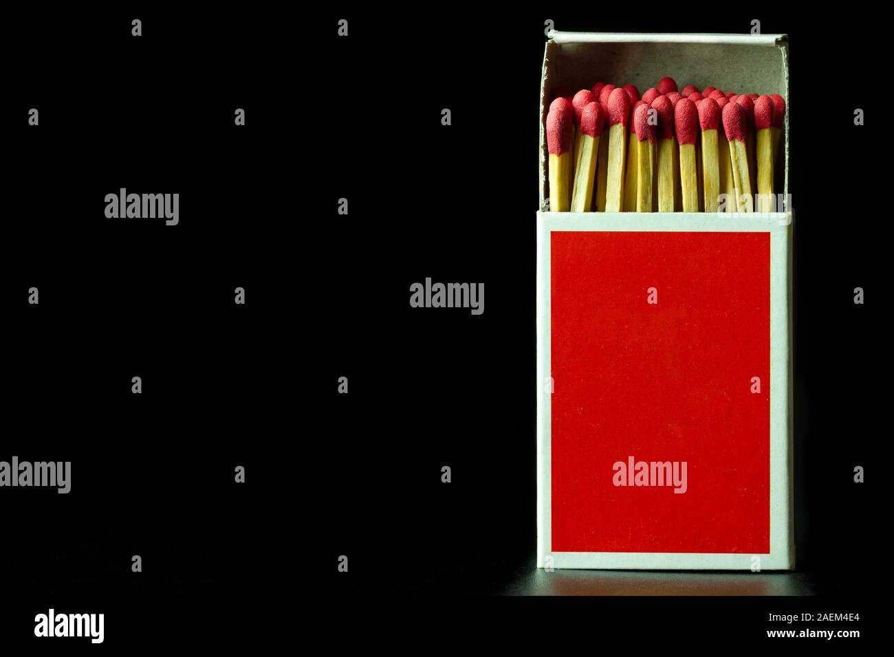 Matches stick in red paper box on black background. Closeup and copy space. Stock Photo