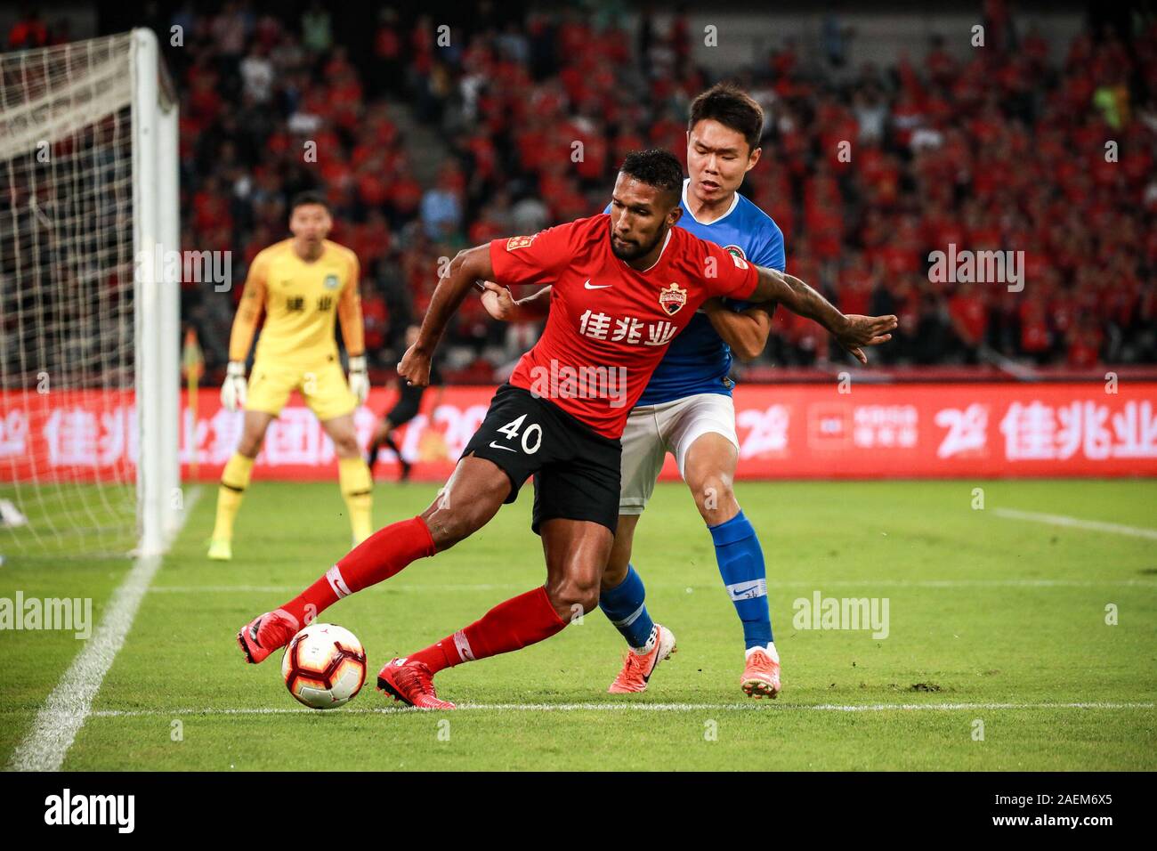 Brazilian-born Portuguese football player Dyego Sousa of Shenzhen F.C., left, protects the ball during the 29th round match of Chinese Football Associ Stock Photo