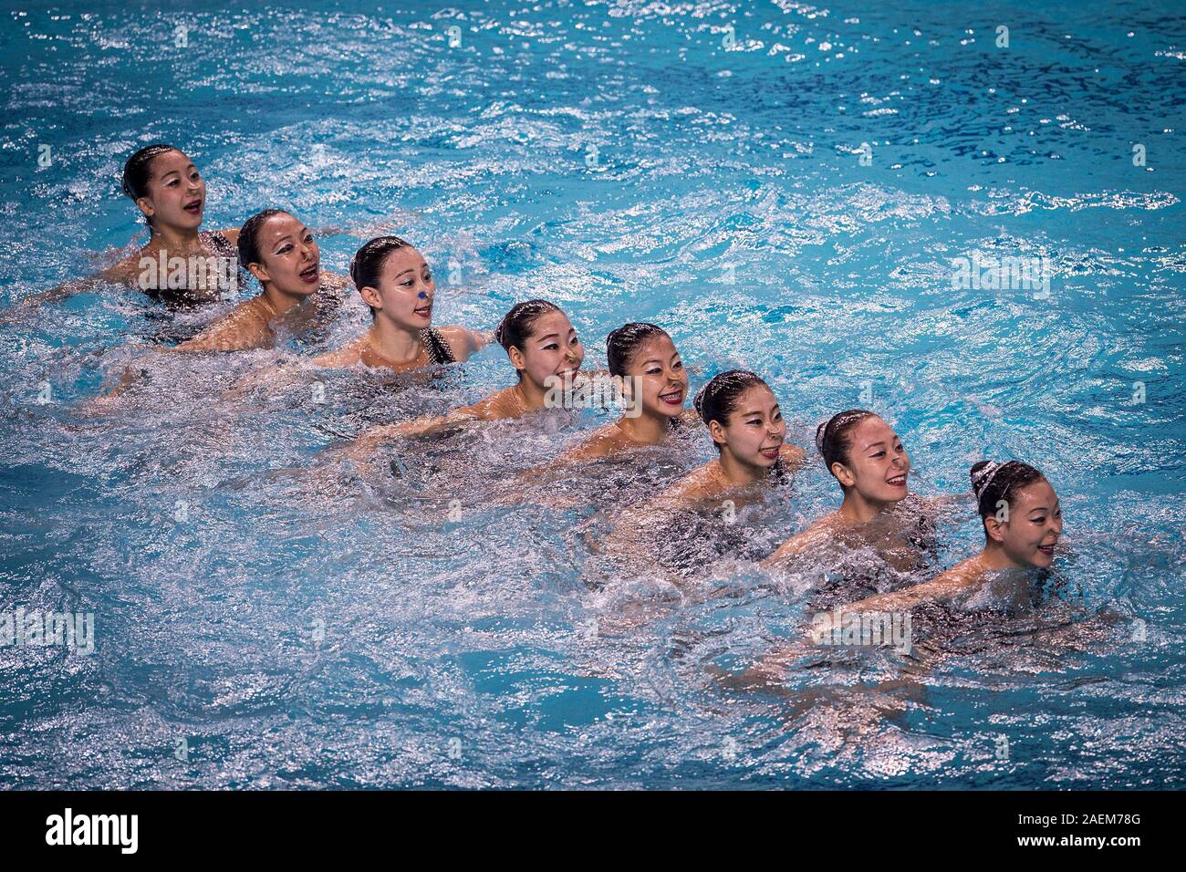 Swimmers do water ballet at the free combination synchronized swimming