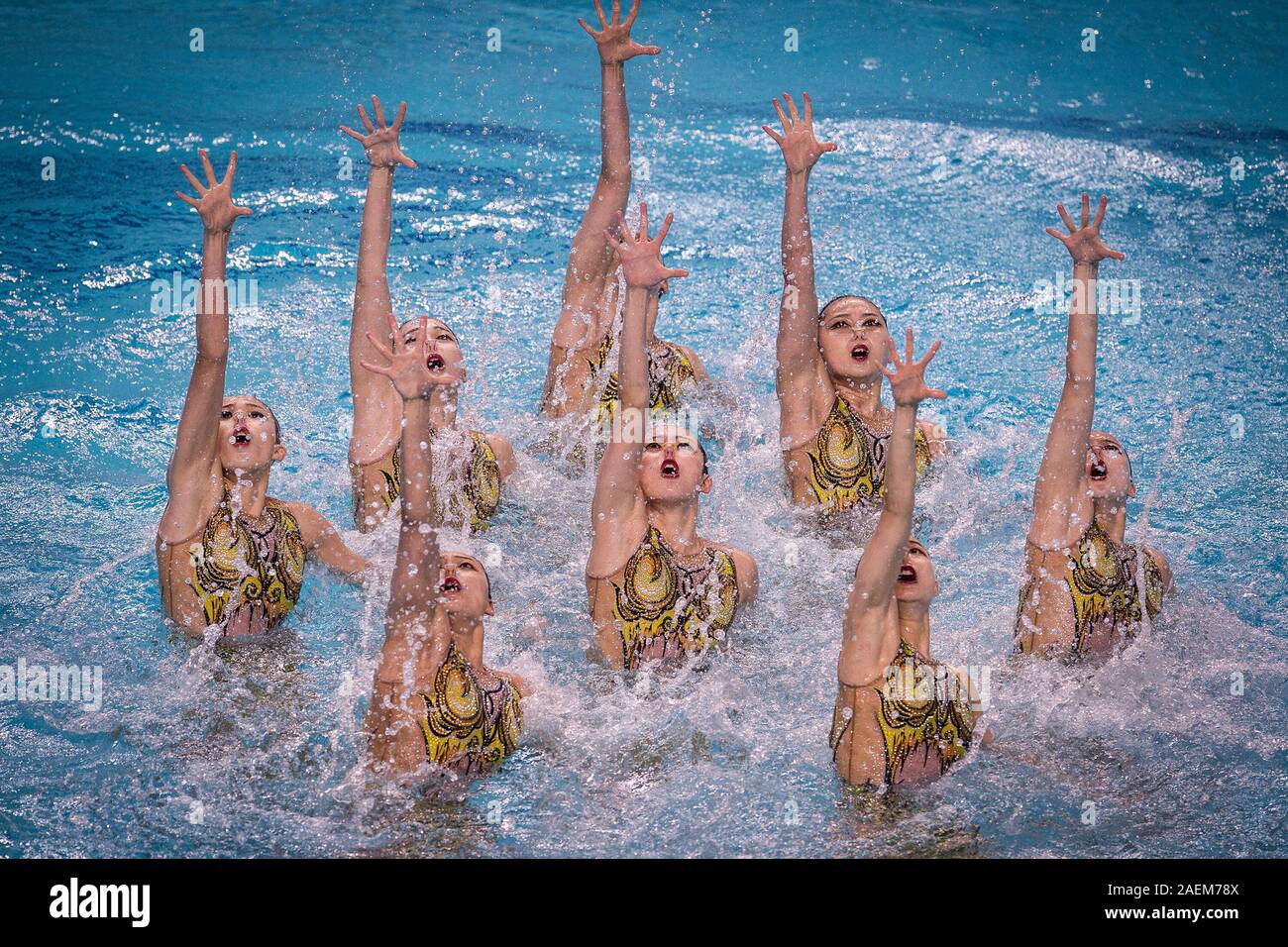 Swimmers do water ballet at the free combination synchronized swimming