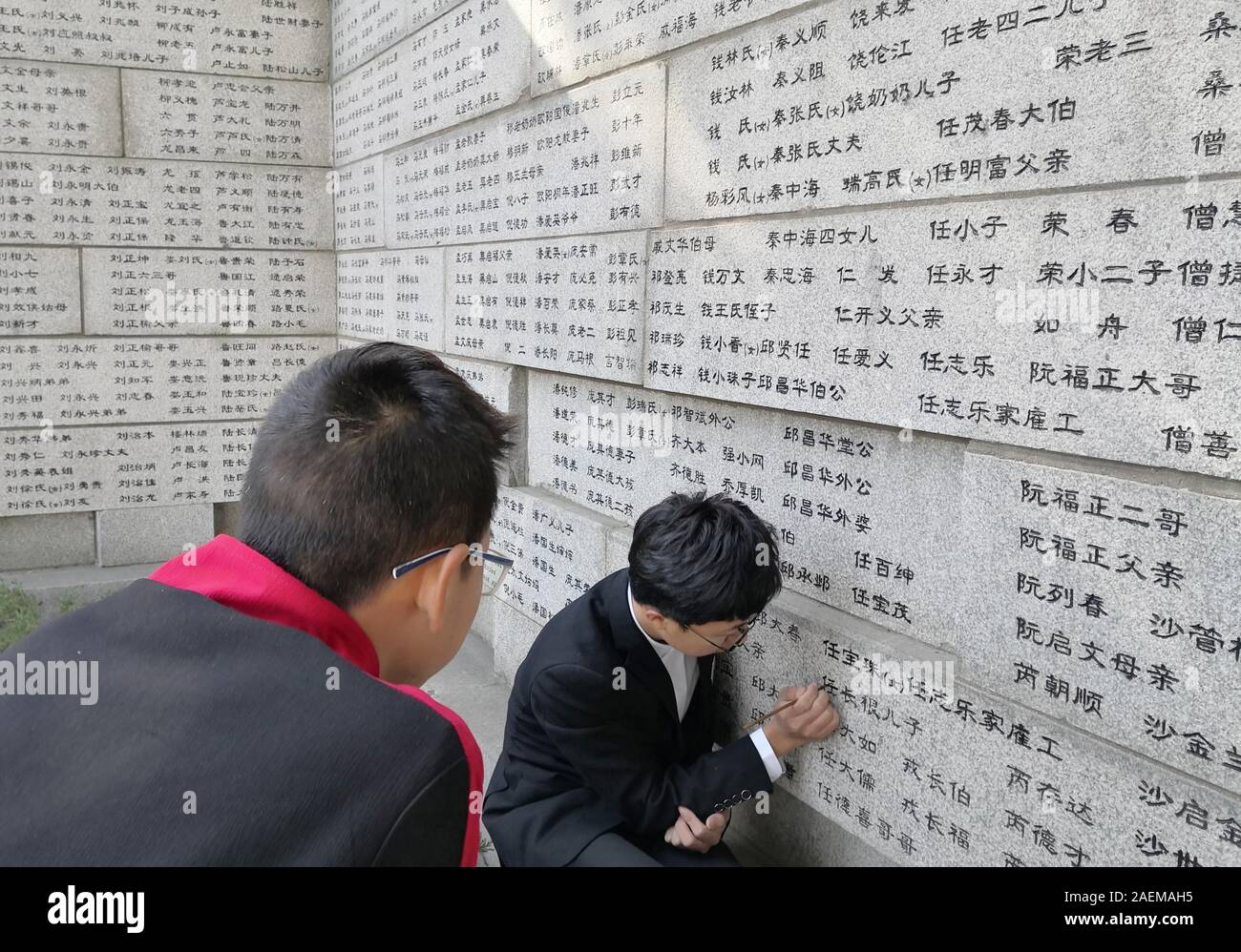 Volunteers from local universities trace the names of victims, who were killed by Japanese soldiers during the Nanjing Massacre in Anti-Japanese War i Stock Photo