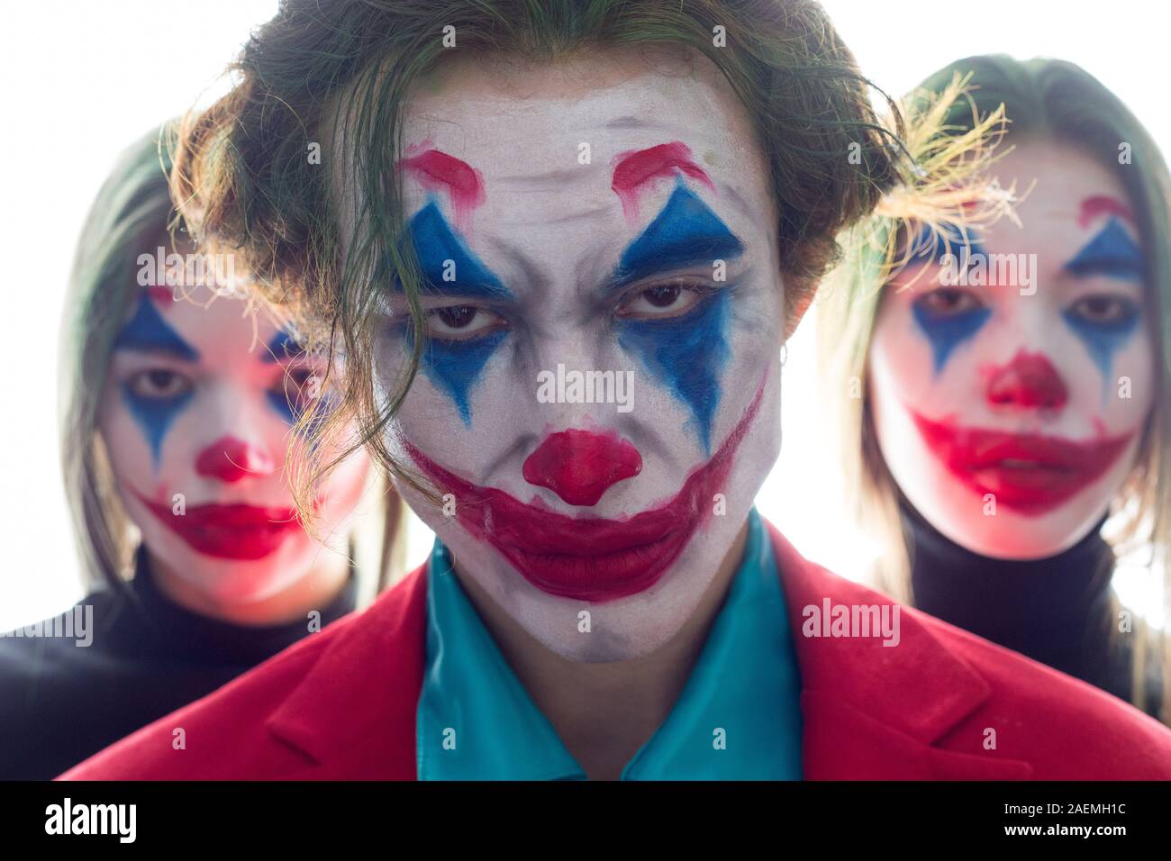 Portrait of three people with clown makeup on a black background Stock