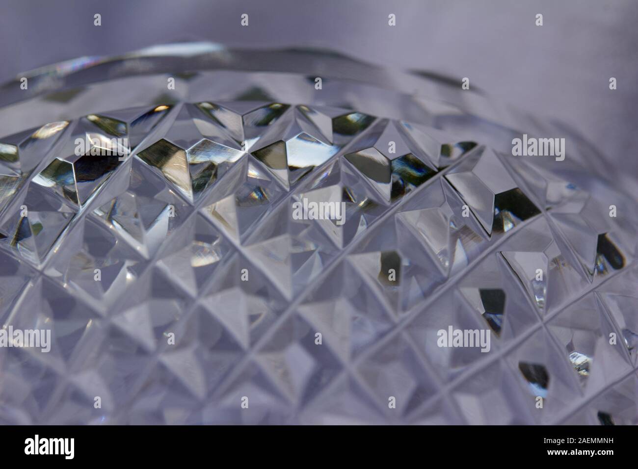 Macro abstract texture background of sparkling hand-cut lead crystal glass with diamond facets, reflecting bright natural light Stock Photo