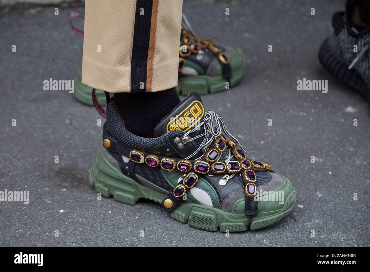 MILAN, ITALY - SEPTEMBER 2019: Man with green and black Gucci sneakers with purple gems decoration before Boss fashion show, Milan Fashion Week st Photo - Alamy