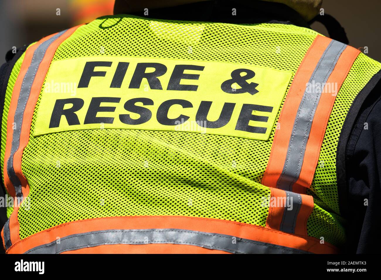 closeup of high visibility clothing with the words or text fire and rescue seen on a fireman or emergency responder outdoors Stock Photo
