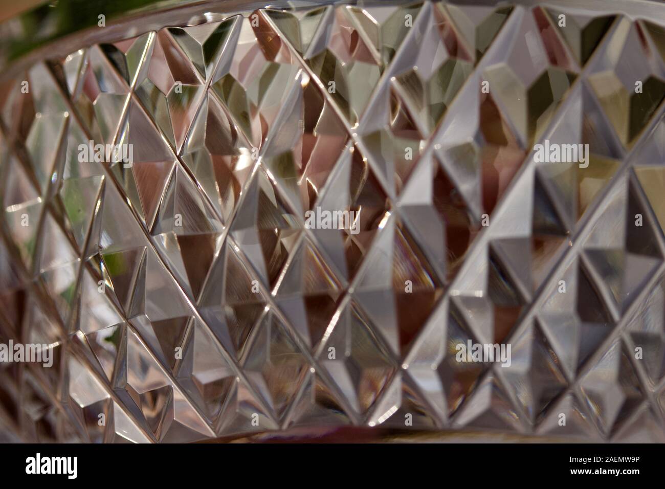 Macro abstract texture background of sparkling hand-cut lead crystal glass with diamond facets, reflecting bright natural light Stock Photo