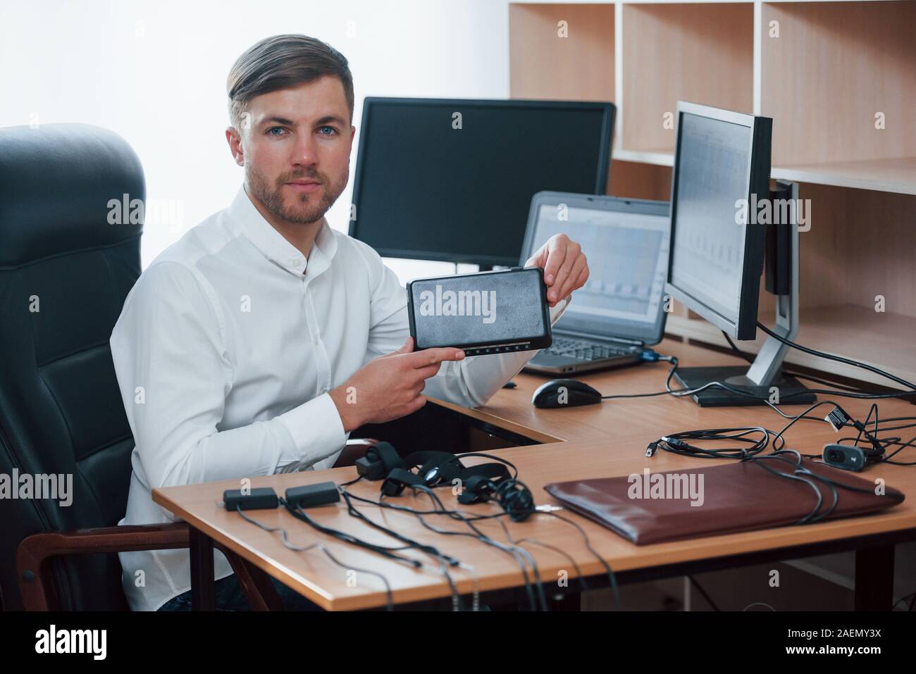 Young professional. Polygraph examiner works in the office with his lie detector's equipment