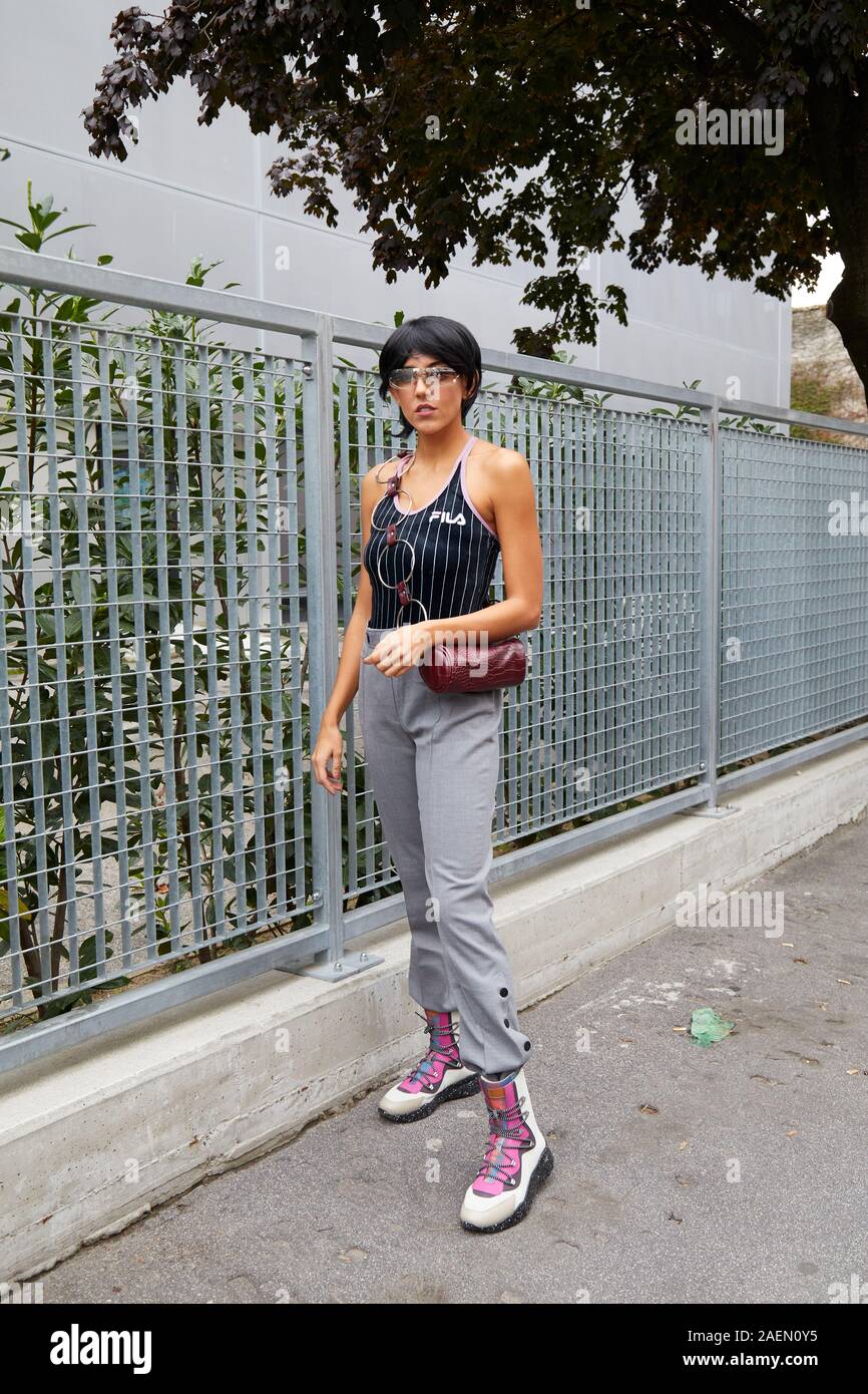 MILAN, ITALY - SEPTEMBER 22, 2019: Woman with black and white striped Fila  tank top and gray trousers before Fila fashion show, Milan Fashion Week str  Stock Photo - Alamy