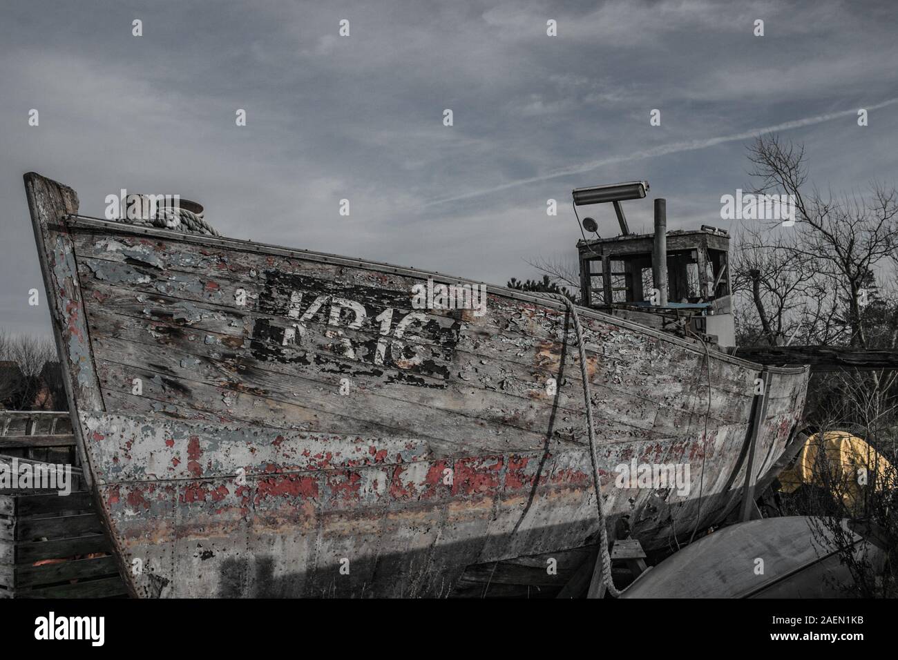Abandoned fishing boat pulled ashore Stock Photo