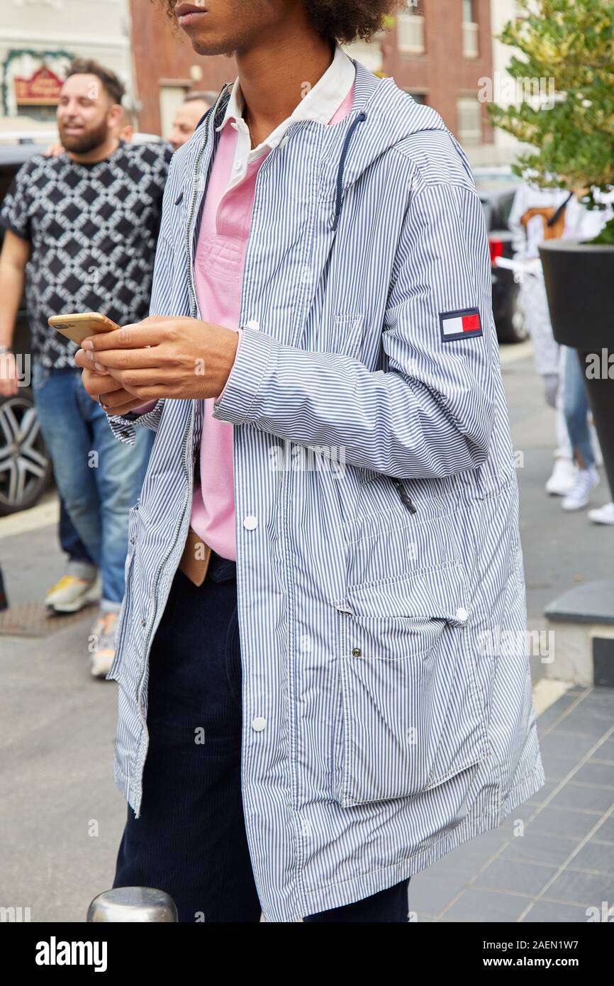 MILAN, ITALY - SEPTEMBER 22, 2019: Man with Tommy Hilfiger white and blue striped jacket and pink polo shirt before Fila fashion show, Milan Fashion W Stock Photo