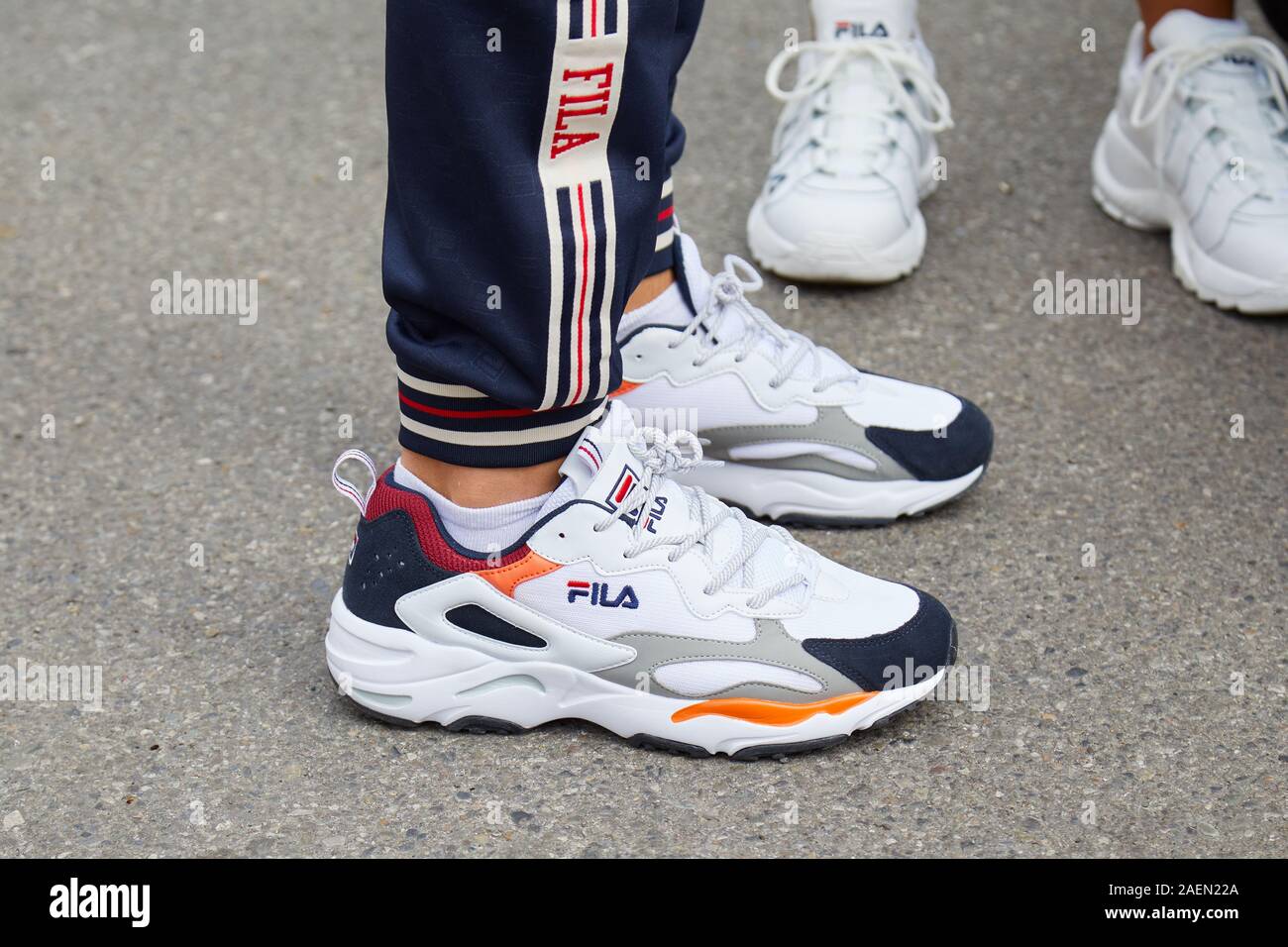 udvande nåde plakat MILAN, ITALY - SEPTEMBER 22, 2019: Man with white, orange and blue Fila  sneakers before Fila fashion show, Milan Fashion Week street style Stock  Photo - Alamy