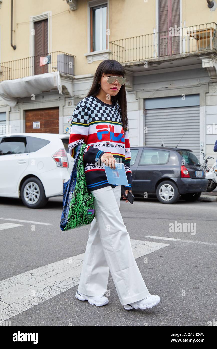 MILAN, ITALY - SEPTEMBER 22, 2019: Woman with colorful Fila sweater white trousers before Fila fashion show, Milan Fashion Week street style Photo - Alamy