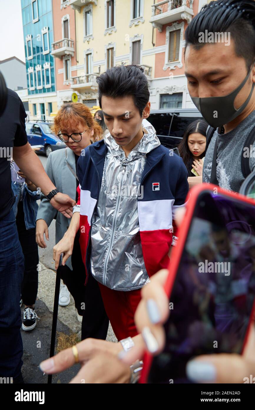 MILAN, ITALY - SEPTEMBER 22, 2019: Man with silver, blue, white and red Fila jacket before Fila fashion show, Milan Fashion Week street style Stock Photo