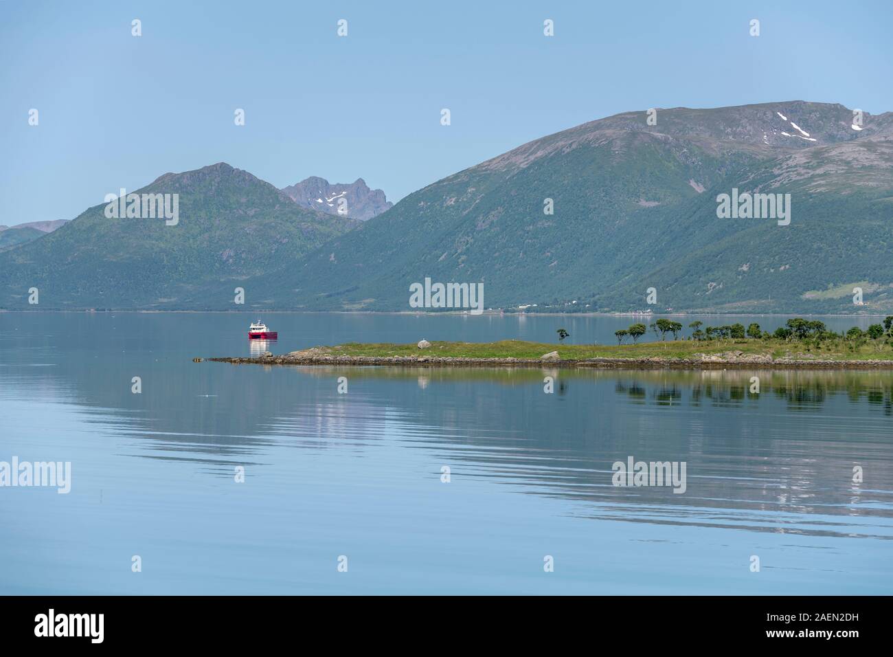 Small Promontory landscape with small boat and green low promontory, shot under bright ...
