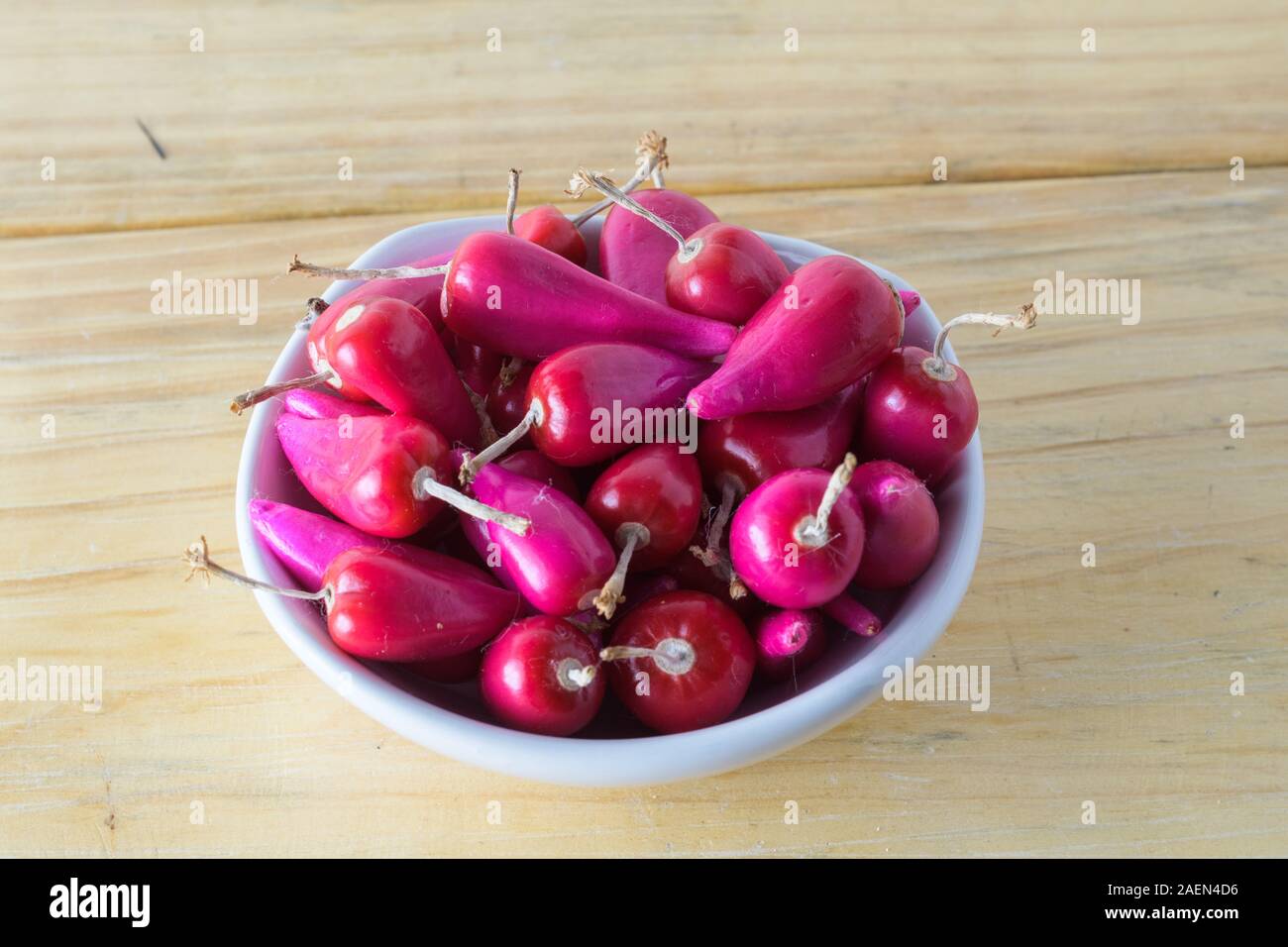 Fresh Pitiguey tropical fruits into white bowl on wood table background Stock Photo