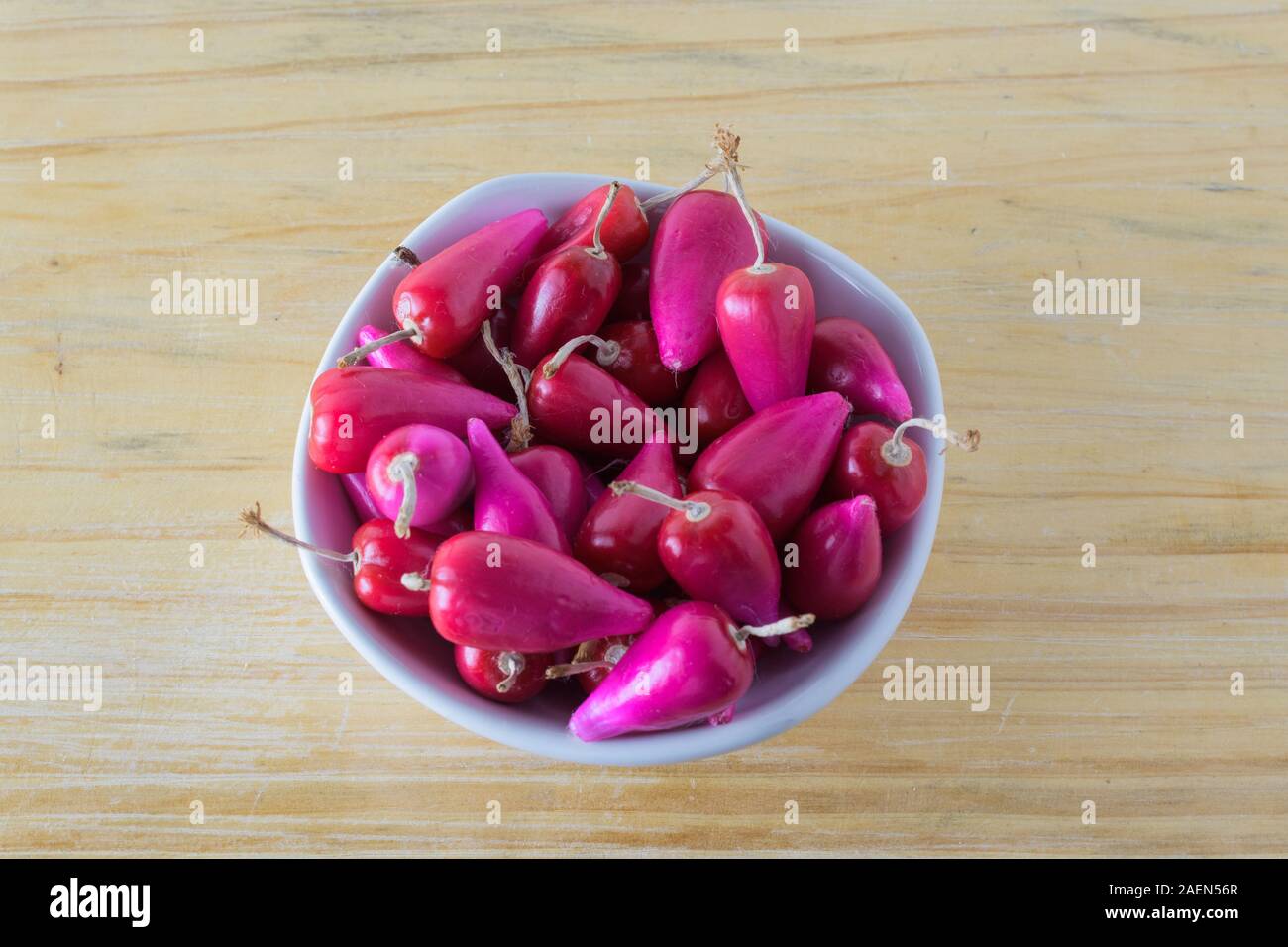 Pitiguey tropical fruit in white bowl on wood table. Top Down. Stock Photo