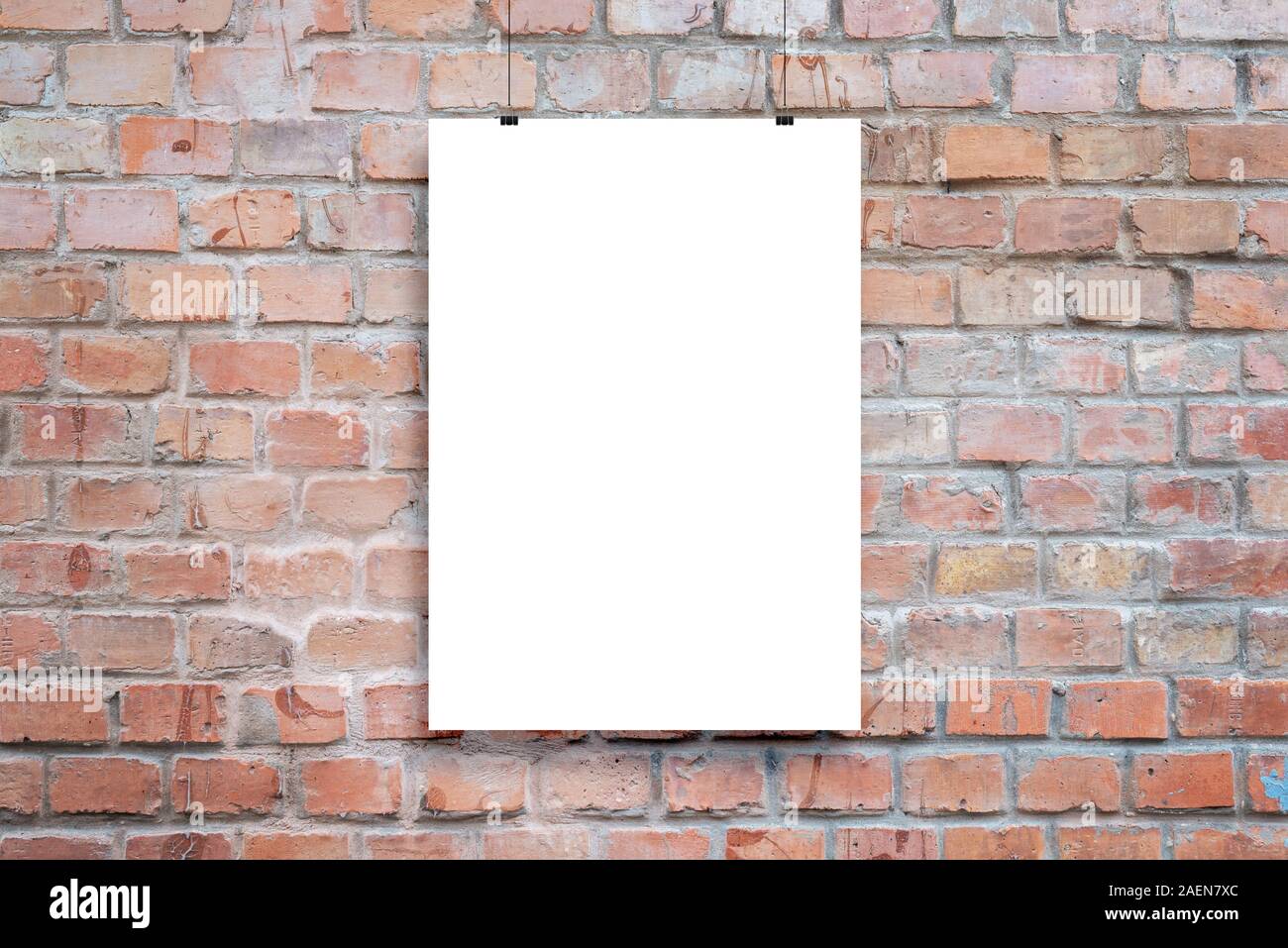 Poster design presentation mockup. Blank paper poster hanging attached with clips across brick