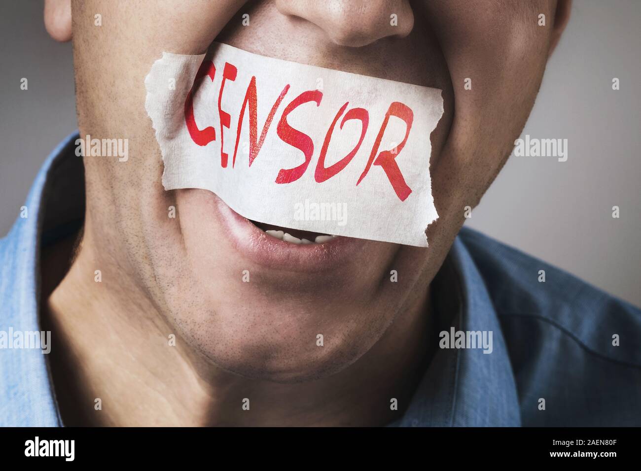 Censorship in society. A man is trying to scream, but his mouth is sealed with adhesive tape with the words censor, close-up Stock Photo