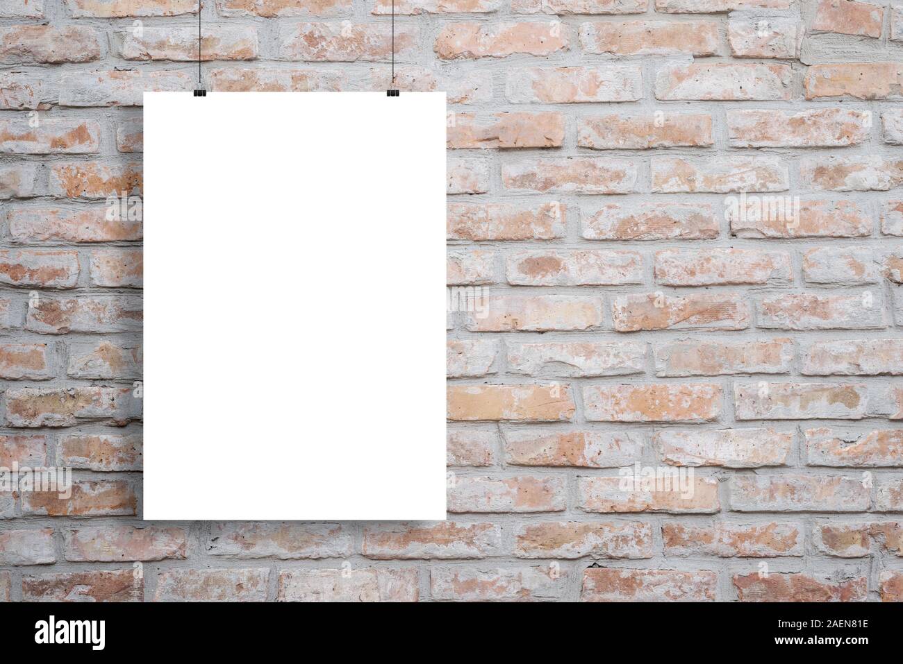 Blank poster mockup hanging across brick wall with copy space beside Stock Photo
