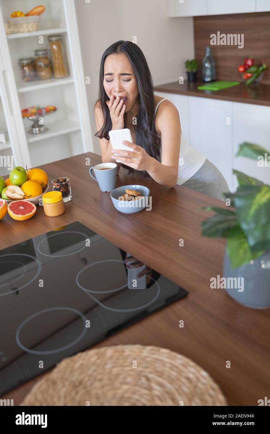 Asian young woman sobbing violently at breakfast Stock Photo
