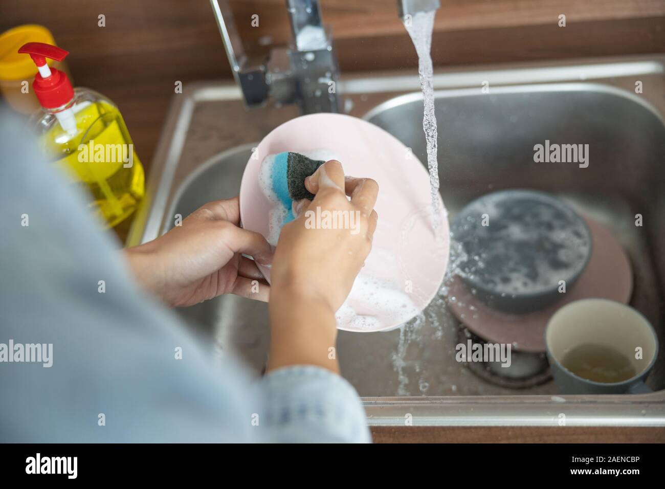 Young woman washing the dishes by hand Stock Photo Alamy