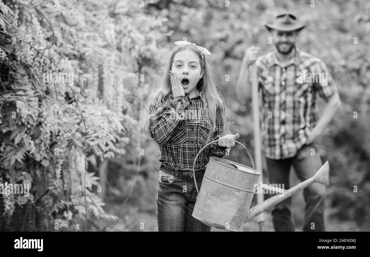 little girl and happy man dad. earth day. family farm. spring village country. father and daughter on ranch. ecology. Watering can and shovel. Beautiful female florist. Passionated about her job. Stock Photo