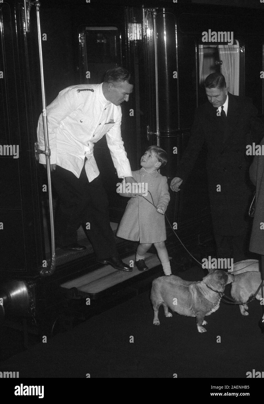 Prince Andrew with a Royal corgis he is helped down on to the platform after arriving at Liverpool Street Station, London, with his mother, Queen Elizabeth II, from King's Lynn and the annual stay at Sandringham. Stock Photo