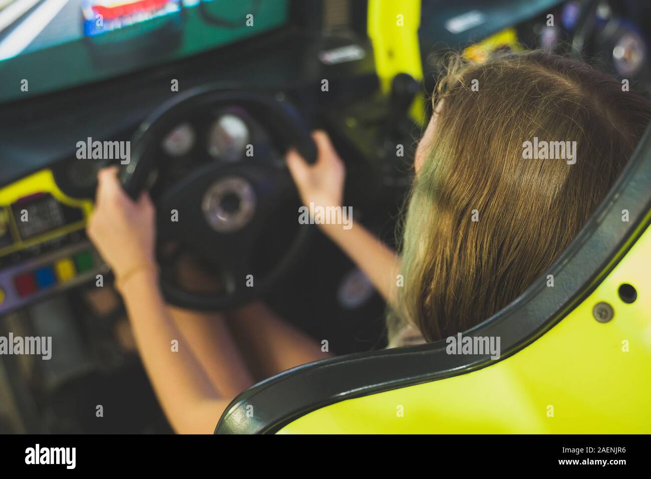 Little girl playing racing simulator game in theme park Stock Photo - Alamy