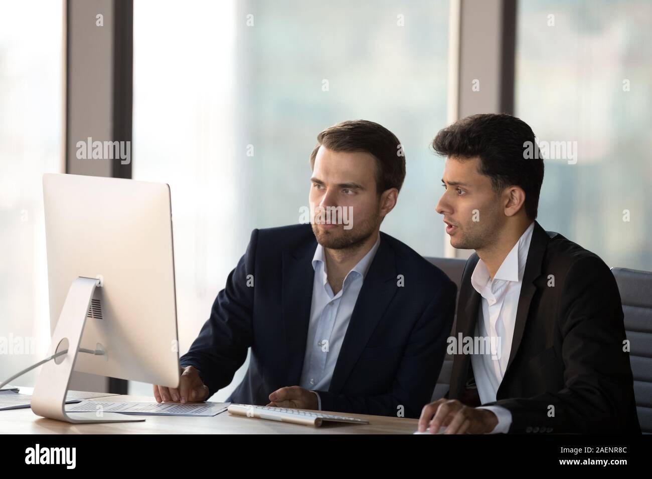 Arabian businessman mentor helping intern with corporate software Stock Photo