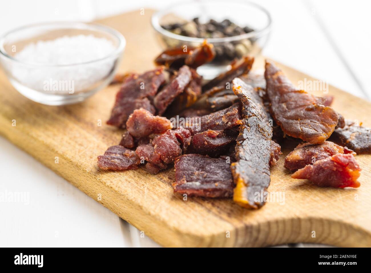 Beef jerky pieces. Dried beef meat on cutting board. Stock Photo