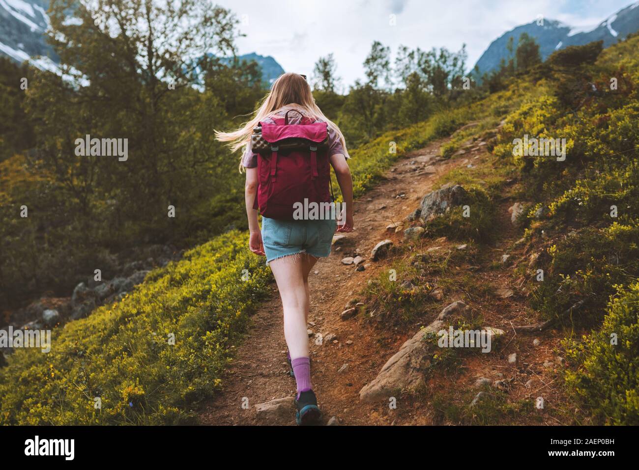 Woman tourist hiking alone in mountains with backpack adventure healthy active lifestyle outdoor summer trekking in Norway Stock Photo