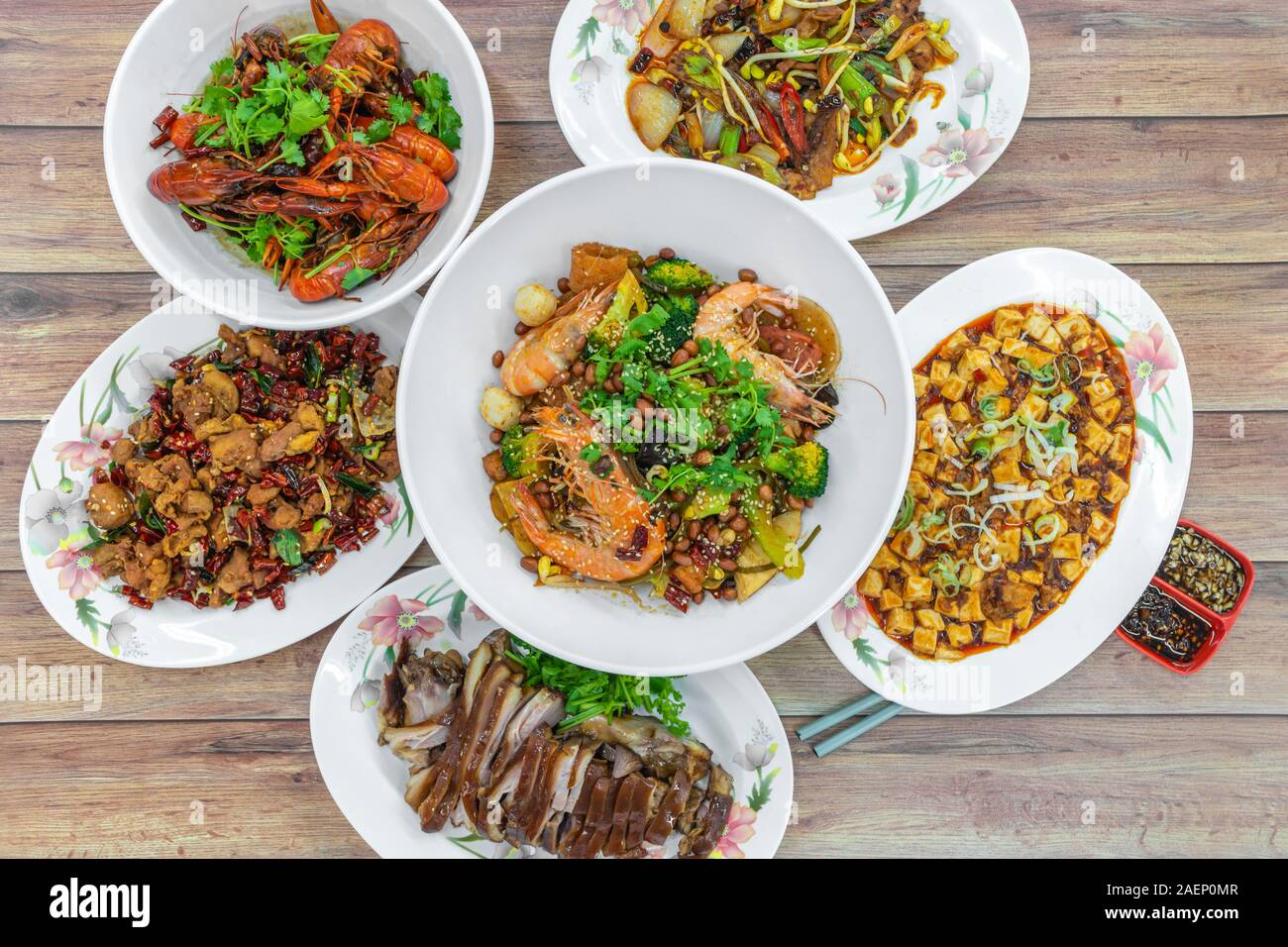 Assorted traditional dishes such as Fragrant Hotpot, crispy fried chicken, mini lobsters, spicy bean curd mapo doufu. Flat lay top down view of table Stock Photo