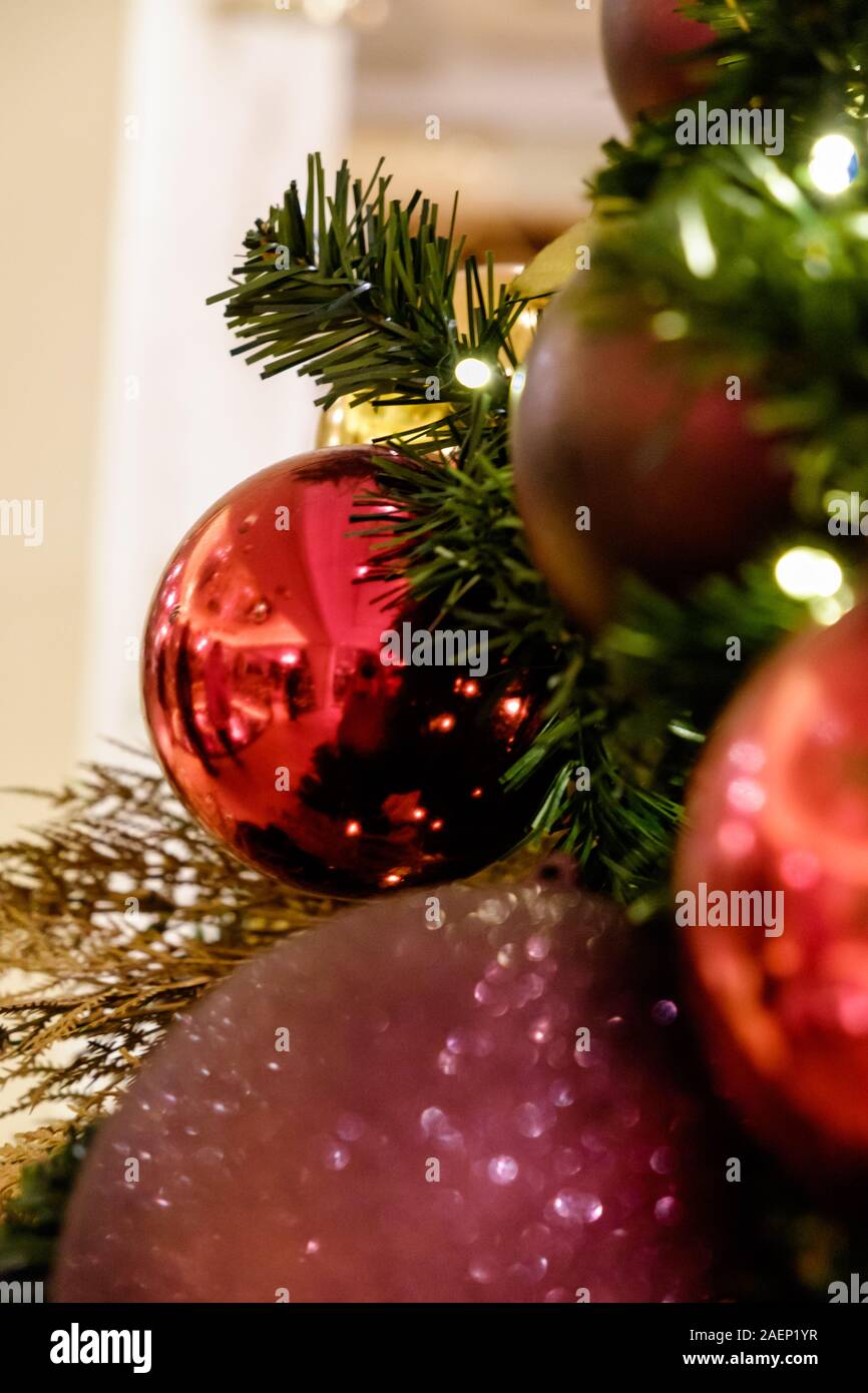 Close Up of Christmas Tree with colourful red purple and gold baubles and decorations. Stock Photo