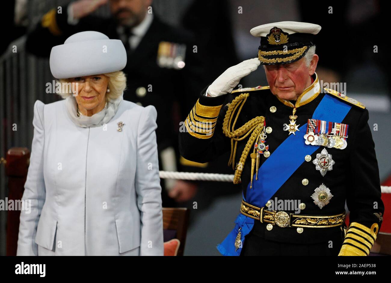The Prince of Wales salutes the White Ensign watched by the Duchess of Cornwall, during the commissioning ceremony of the Royal Navy aircraft carrier, HMS Prince of Wales, at Portsmouth Naval Base. Stock Photo