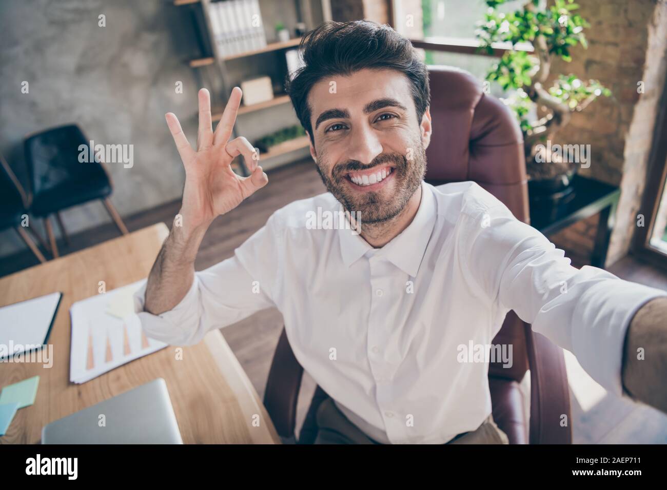Close up photo of positive middle eastern collar ceo worker having online connection meeting on team working training make selfie show ok sign approve Stock Photo
