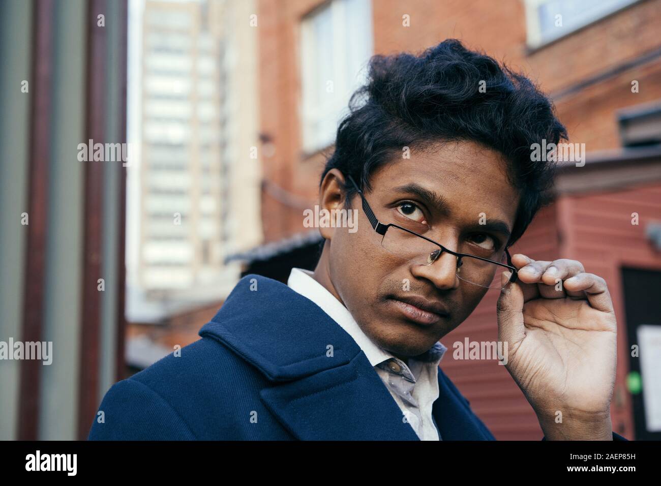 Handsome young mixed race man looking over his glasses.  Stock Photo