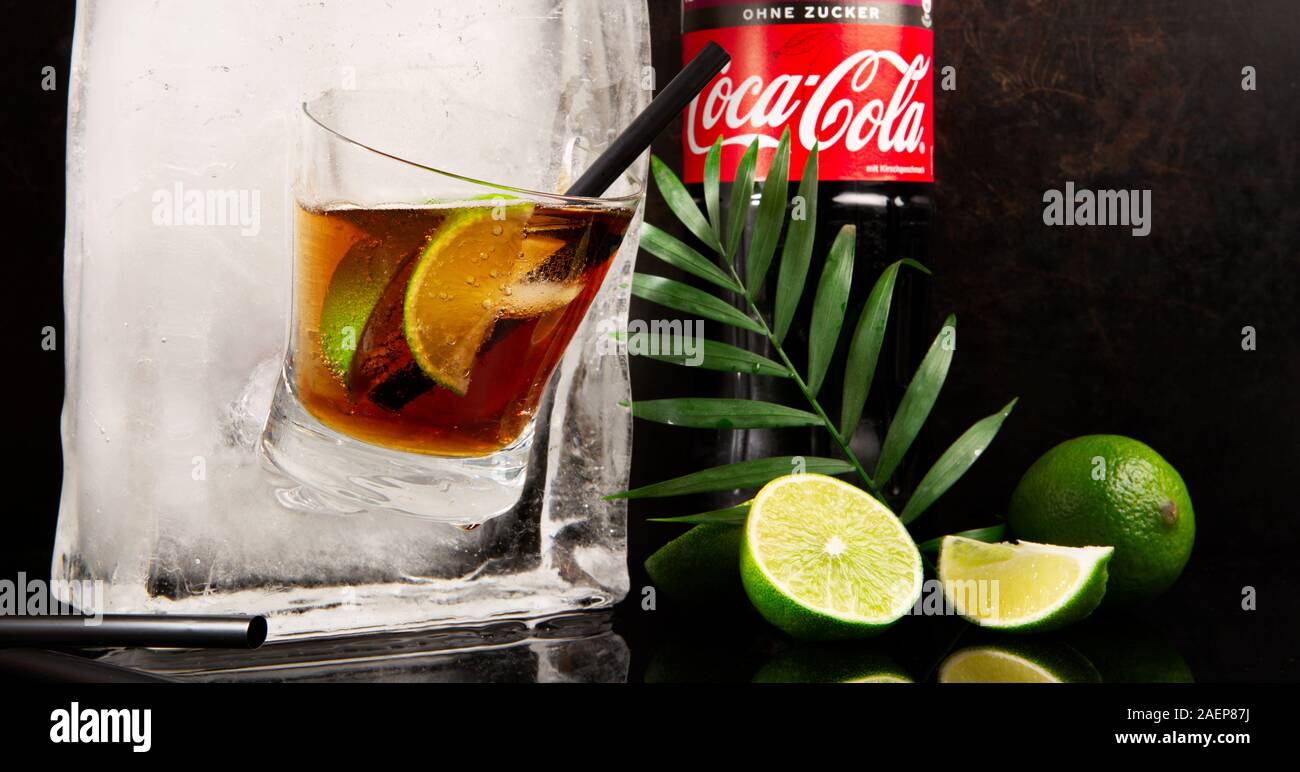Coca Cola in a Glass with Bottle Ice Cube - Ice Melting - Black Background Stock Photo